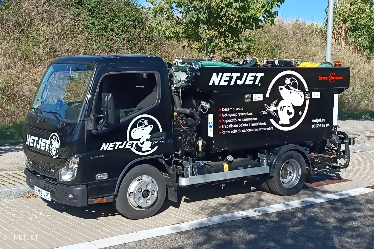 "Camión de NetJet especializado en desatascos y limpieza de tuberías, estacionado en una zona pavimentada con árboles de fondo. En los laterales, se destacan los servicios ofrecidos, como desatascos, limpieza preventiva, inspección de tuberías y reparación sin obra. NetJet brinda soluciones profesionales con atención 24 horas.